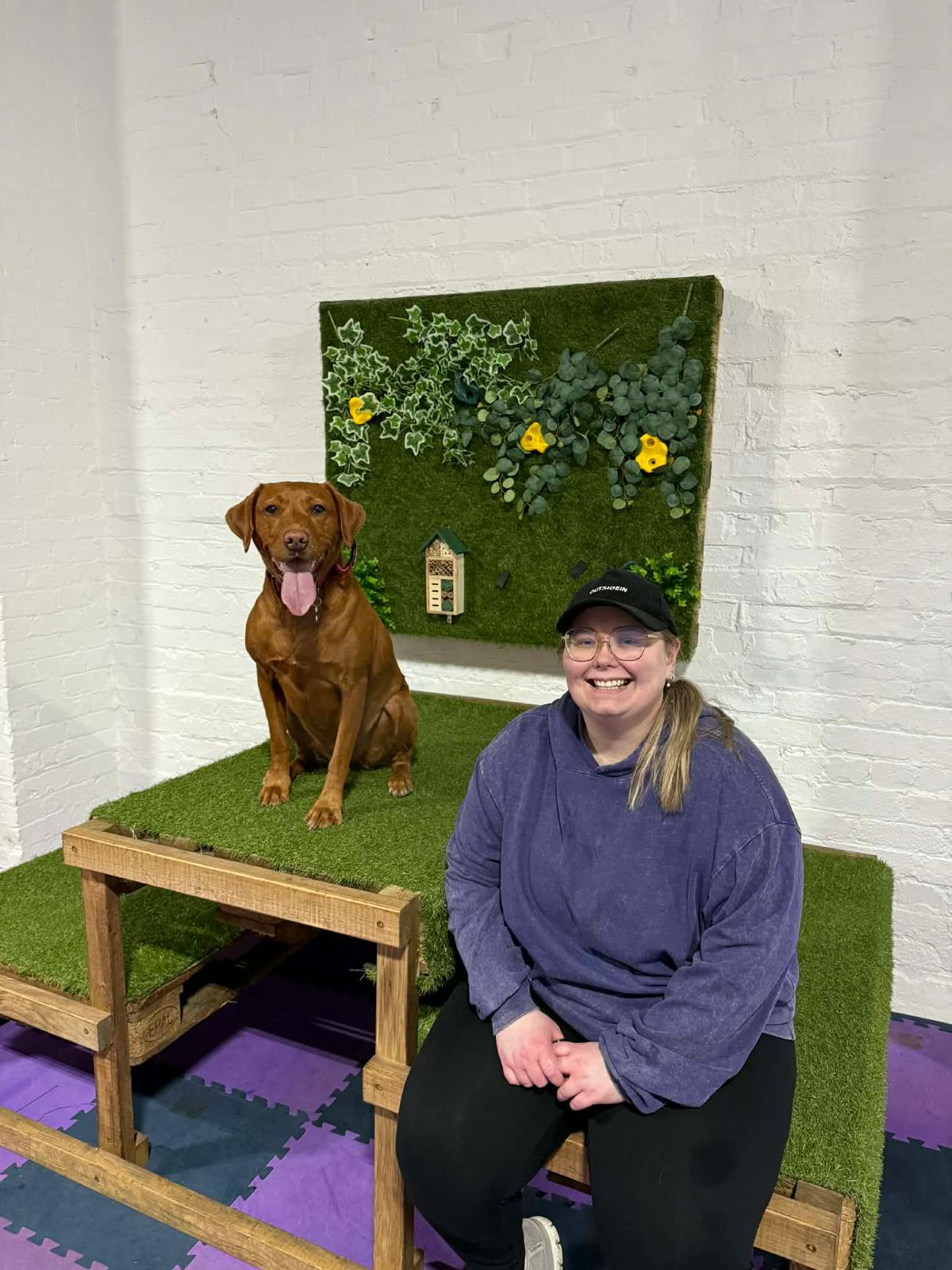 Ruth sitting beside her working Labrador Ruby at Dogs Country Club
